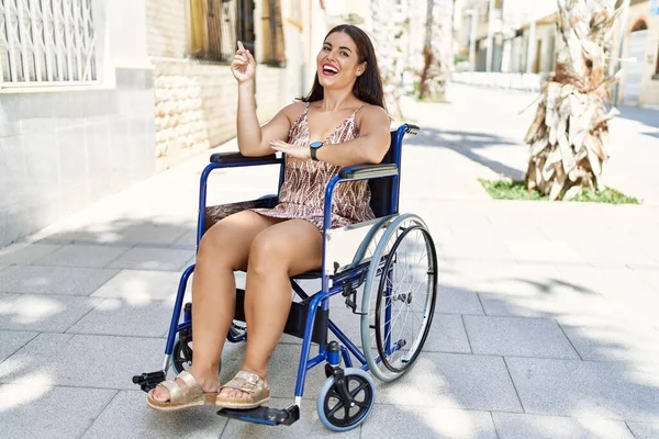 Young Brunette Woman Sitting Wheelchair Outdoors Smiling Happy Pointing Hand — Stock Photo, Image