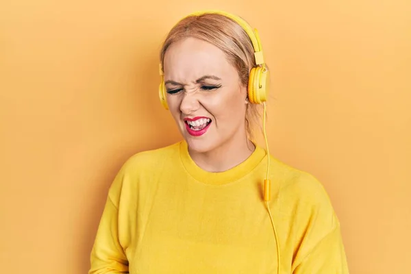 Mujer Rubia Joven Escuchando Música Usando Auriculares Con Mano Estómago — Foto de Stock