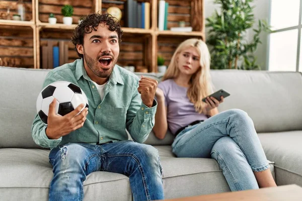 Homem Sorrindo Feliz Assistindo Jogo Futebol Namorada Chato Usando Smartphone — Fotografia de Stock