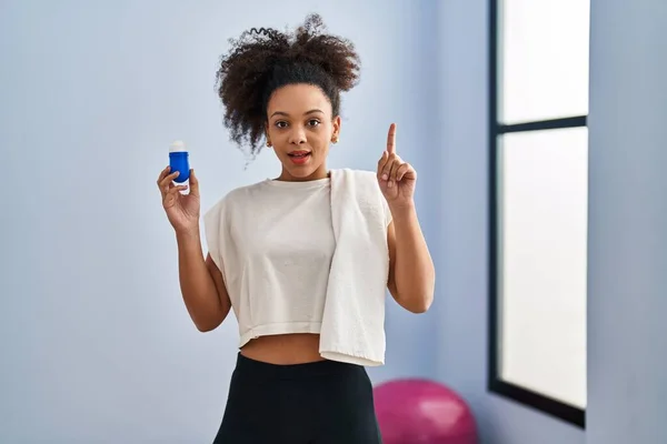 Young African American Woman Wearing Sportswear Towel Holding Deodorant Surprised — Stok fotoğraf