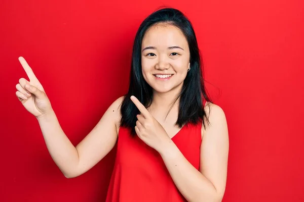 Młoda Chińska Dziewczyna Luźnych Ubraniach Uśmiechnięta Patrząca Kamerę Dwoma Rękami — Zdjęcie stockowe