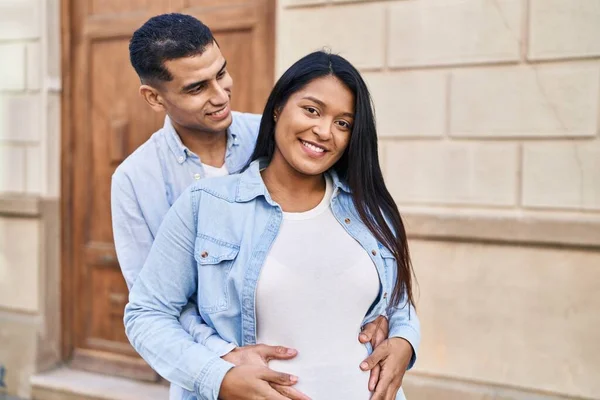 Young Latin Couple Expecting Baby Hugging Each Other Standing Street — Stockfoto