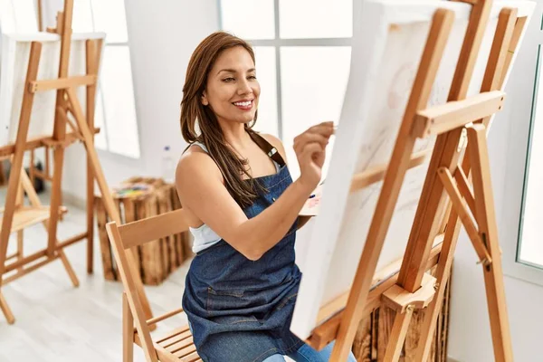 年轻的惊慌失措的艺术家女人在画室里开心地微笑着 — 图库照片