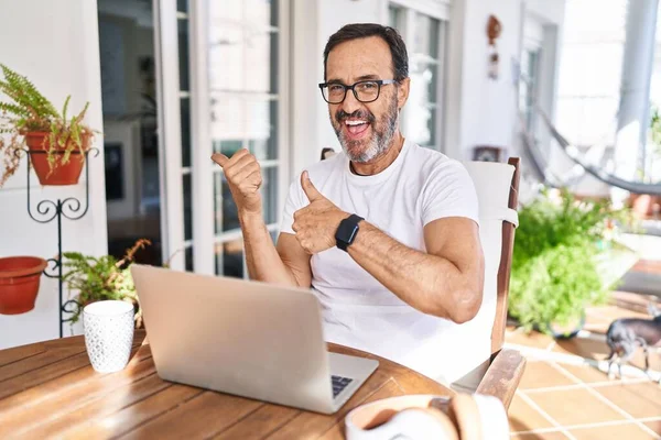 Hombre Mediana Edad Usando Computadora Portátil Casa Apuntando Hacia Atrás —  Fotos de Stock