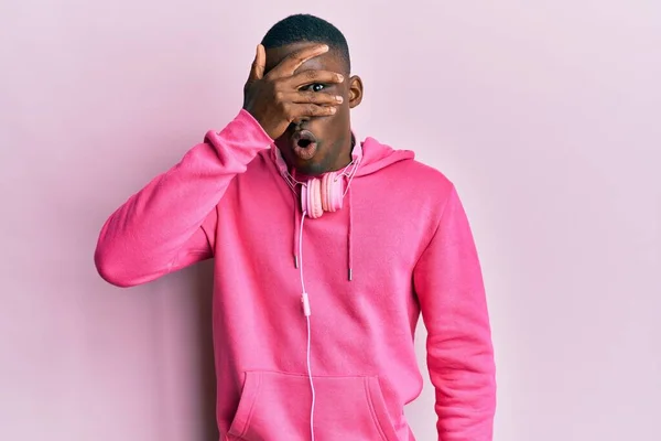 Young African American Man Wearing Gym Clothes Using Headphones Peeking — Stockfoto