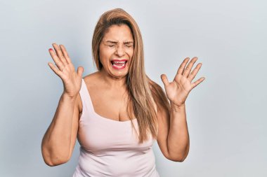 Kolları havada, gözleri kapalı heyecanlı bir şekilde bağıran, kolları açık, kolları açık, kolları açık, kolsuz tişörtlü orta yaşlı İspanyol kadın başarıyı deli ve çılgın bir şekilde kutluyor. Kazanan konsept 