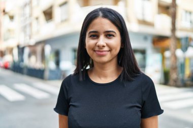 Sokakta kendine güvenen genç Latin kadın gülümsüyor