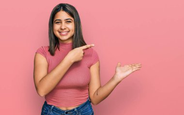 Gündelik tişört giyen genç İspanyol kız kameraya hayret ediyor ve gülümsüyor.. 