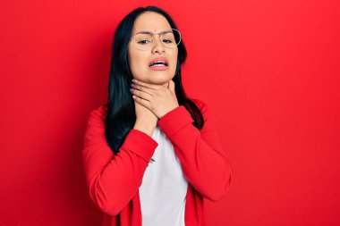 Burnuna piercing takan, sıradan bakışlar atan, gözlük takan bağıran ve boğulan güzel İspanyol bir kadın. Çünkü acı verici bir şekilde boğuldu. Sağlık problemi. Boğulma ve intihar konsepti. 