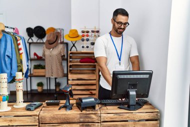Genç İspanyol esnaf mağazada çalışırken gülümsüyor.
