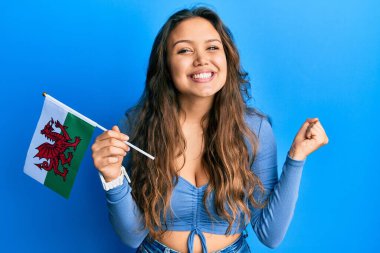 Galler bayrağı tutan genç İspanyol kız gururla haykırıyor, zaferi ve başarıyı kutluyor. 