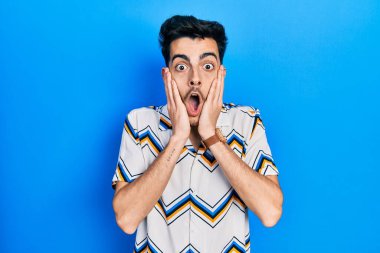 Günlük kıyafetler giyen genç İspanyol adam korkmuş ve şok olmuş, şaşırmış ve şaşırmış bir yüz ifadesi takınmıştı. 