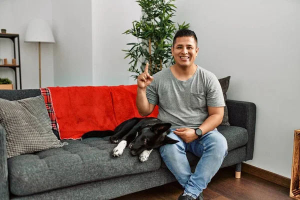Young Latin Man Dog Sitting Sofa Home Puffing Cheeks Funny — Stockfoto