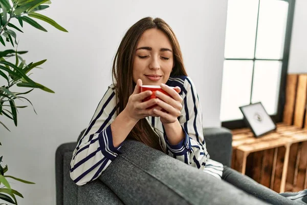 Jonge Spaanse Vrouw Die Thuis Koffie Drinkt Bank — Stockfoto