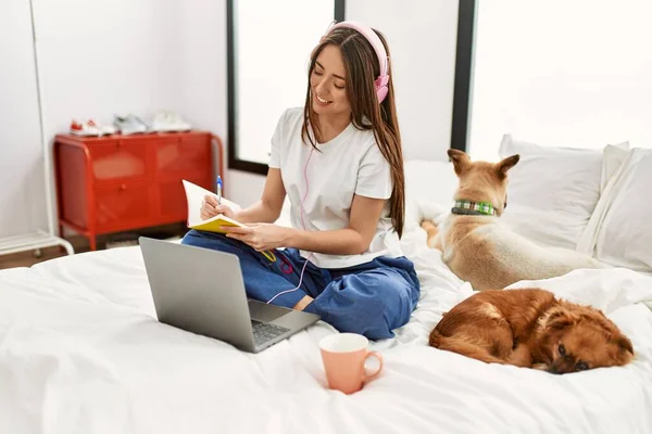 若いですヒスパニック女性研究上のベッドで犬とともにベッドルーム — ストック写真