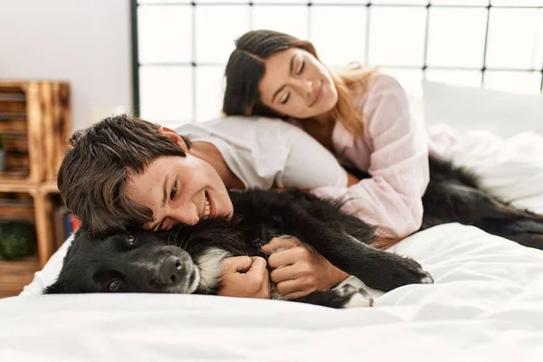 Young Caucasian Couple Smiling Happy Lying Bed Playing Dog Home — Stock Photo, Image