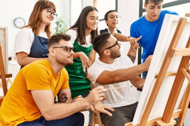 Mutlu gülümseyen ve ortak arayan bir grup insan sanat stüdyosunda..