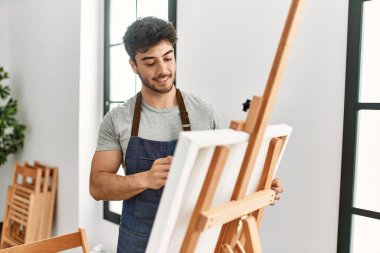 Resim stüdyosunda gülümseyen genç İspanyol ressam..