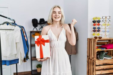 Kafkasyalı genç bir kadın perakende dükkanında hediyesini tutuyor. Gururla bağırıyor, zaferi kutluyor ve kollarını kaldırıp başarıyı kutluyor. 