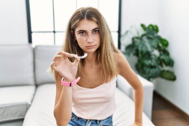 Genç sarışın kadın, görünmez hizaya gelmiş, ortodontik şüpheci ve gergin, sorun yüzünden kaşlarını çatıyor. negatif kişi. 