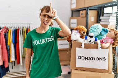 Bağışta gönüllü tişört giyen güzel beyaz kadın parmakları alnında insanlarla dalga geçiyor. Ezik hareketler yapıyor, alay ediyor ve hakaret ediyor.. 