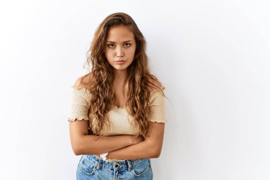 Güzel İspanyol kadın izole edilmiş vaziyette dururken, arka plan şüpheci ve gergin, kollarını kavuşturmuş yüz ifadesini onaylamıyor. negatif kişi. 