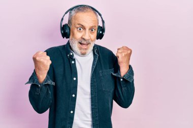 Sakallı, müzik dinleyen, kulaklık takan yakışıklı bir adam. Kollarını kaldırıp, gözlerini açarak başarıyı kutluyor. Kazanan konsept. 