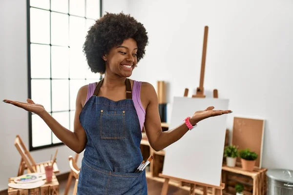 アフリカ系アメリカ人の若い女性がアートスタジオで笑顔で両手を開いて手のひらを示す 提示し 広告の比較とバランス — ストック写真
