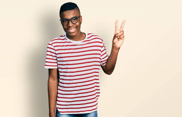 年轻的非洲裔美国人 身穿休闲装 戴着眼镜 手指头一指二指 面带微笑 自信而快乐 — 图库照片