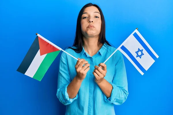 Jovem Latina Segurando Bandeiras Palestinas Israelenses Soprando Bochechas Com Rosto — Fotografia de Stock