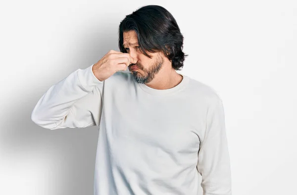 中年の白人男性はカジュアルな服を着て何か臭いと嫌な 耐え難い匂いを嗅ぎ 鼻の上に指で息を保持します 臭いが悪い — ストック写真
