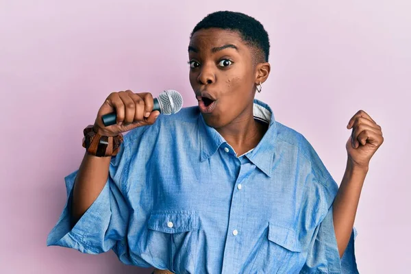 Mladá Africká Americká Žena Zpívající Píseň Pomocí Mikrofonu Vystrašený Ohromený — Stock fotografie
