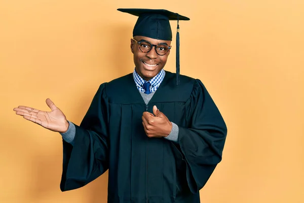 Jonge Afro Amerikaanse Man Met Afstudeerpet Ceremoniële Badjas Met Palmhand — Stockfoto