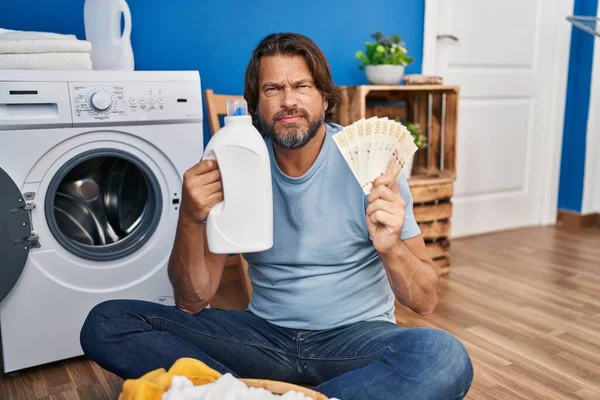 ハンサムな中年の男性洗濯洗剤懐疑的で緊張のお金を節約し 問題のために動揺を眉をひそめる 否定的な人 — ストック写真