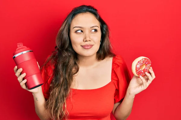 Joven Chica Hispana Comiendo Donut Bebiendo Café Sonriendo Mirando Lado —  Fotos de Stock