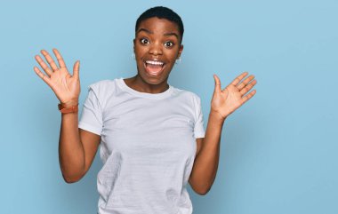 Beyaz bir tişört giyen genç Afro-Amerikalı kadın çılgınlığı kutluyor ve başarıyı kollarını kaldırıp heyecanla haykırarak kutluyor. Kazanan konsept 