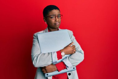 Genç afro-amerikan iş kadını elinde dizüstü bilgisayardan bihaber ve kafası karışık bir ifade tutuyor. şüphe kavramı. 