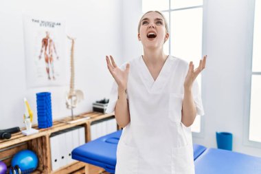 Ağrı giderme kliniğinde çalışan beyaz bir kadın. Deli gibi bağırıyor, bağırıyor, agresif bir ifade ve kollarla bağırıyor. hüsran kavramı. 