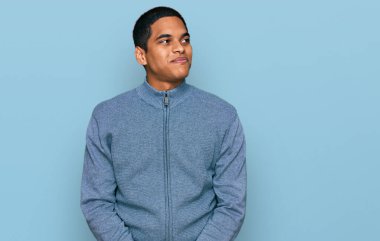 Genç, yakışıklı, sıradan bir tişört giyen, gülümseyen, yan bakan ve düşünen İspanyol bir adam.. 