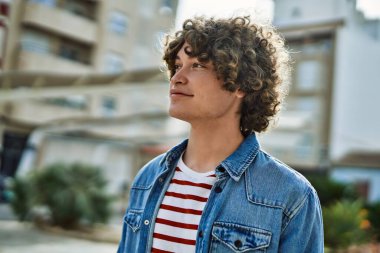 Genç İspanyol adam şehre gülümsüyor.