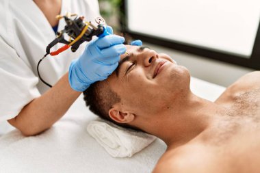 Genç İspanyol adam güzellik merkezinde mikropatenli kaş tedavisiyle rahatladı.