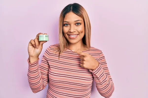 Hermosa Mujer Hispana Sosteniendo Crema Hidratante Cosmética Sonriendo Feliz Señalando —  Fotos de Stock