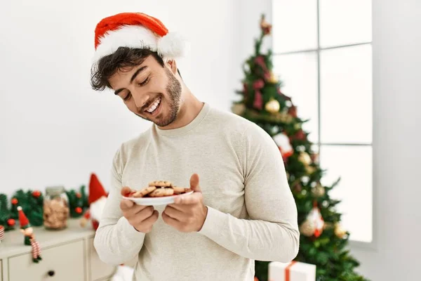 Ung Latinamerikan Man Bär Jul Hatt Hålla Kakor Hemma — Stockfoto