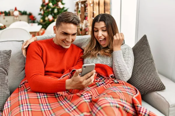 Young Hispanic Couple Sitting Sofa Christmas Screaming Proud Celebrating Victory — Fotografia de Stock