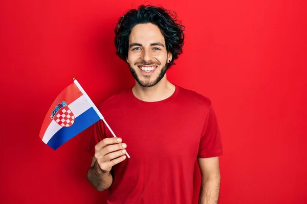 Bonito Homem Hispânico Segurando Bandeira Croácia Olhando Positivo Feliz Sorrindo — Fotografia de Stock