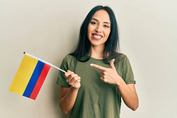 Młoda Latynoska Dziewczyna Trzyma Flagę Kolumbii Uśmiechając Się Szczęśliwy Wskazując — Zdjęcie stockowe