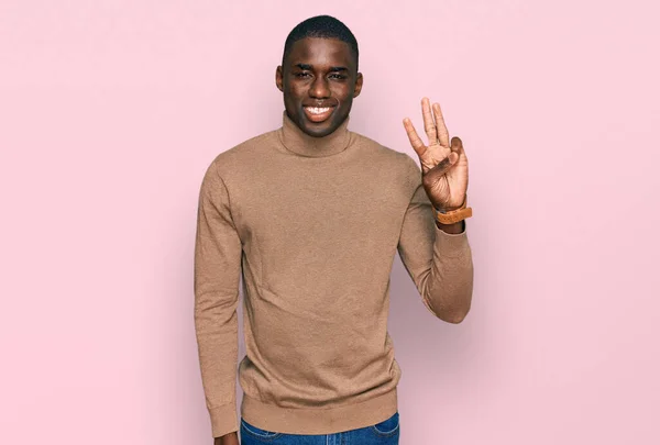 若いですアフリカ系アメリカ人男性身に着けていますカジュアル冬のセーターショーと指差す指数3ながら笑顔自信と幸せ — ストック写真