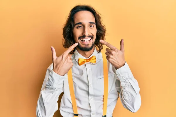 若いヒスパニック系の男を着てヒップスターエレガントな表情を笑顔陽気で 指の歯と口を指しています 歯の健康の概念 — ストック写真