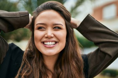 Genç İspanyol kadın gülümseyerek şehirde mutlu mesut dikiliyor..