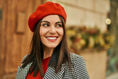 Genç İspanyol kadın gülümseyerek şehirde mutlu mesut dikiliyor..